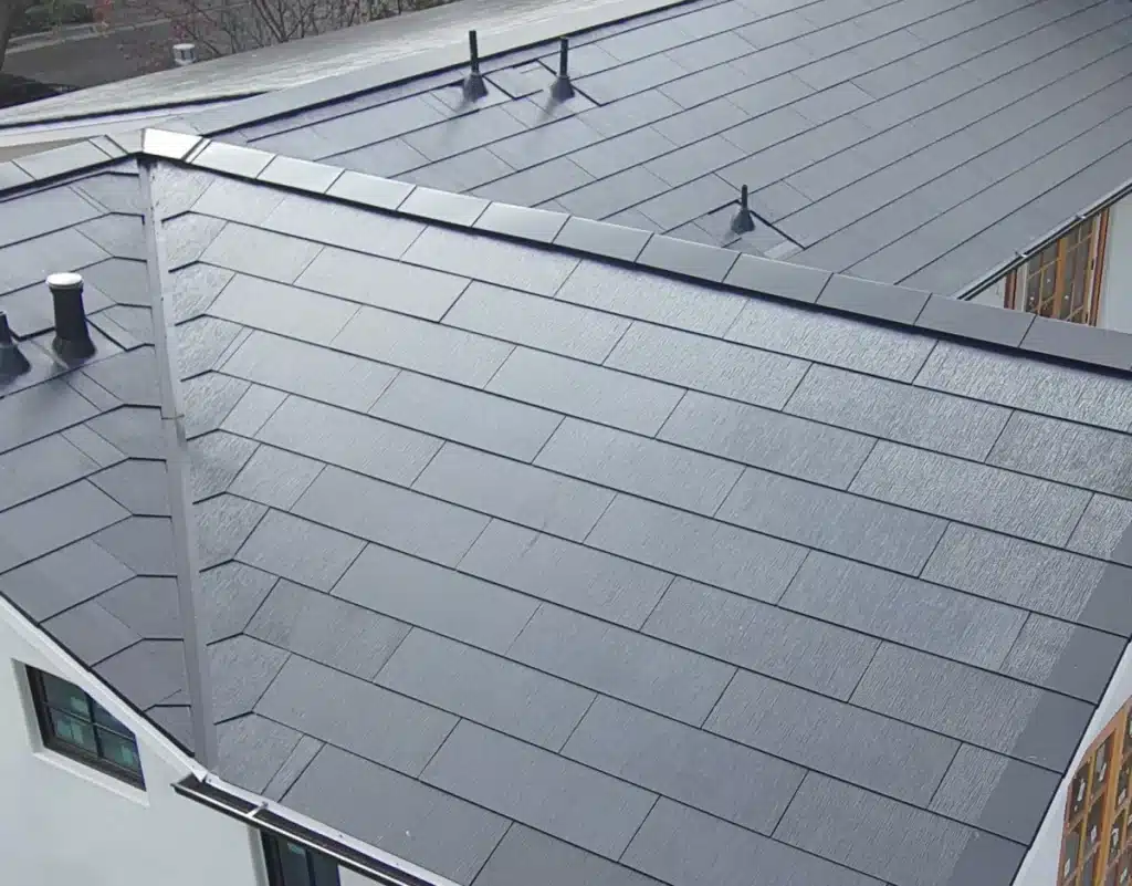 Close-up of a cleanly installed Tesla Solar Roof on a modern residential home, highlighting the sleek design and integrated solar shingles.