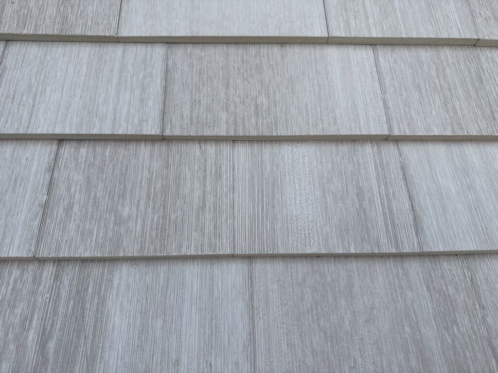 Close-up of NuCedar PVC shingles installed with no gap at butt joints, against manufacturer's required 1/8-inch spacing for thermal expansion