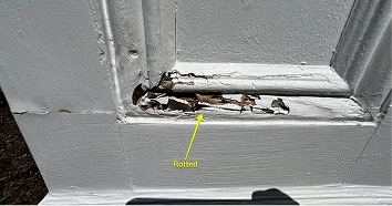 Close-up of through-rot at window surround base — material completely failed, open void visible